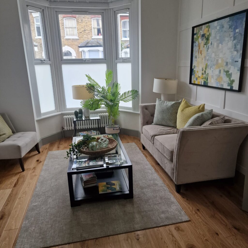 Living Room & Bedroom Renovation | London & Home Counties 7 A living room featuring a beige sofa, coffee table with decor, and a plant in a corner. - London