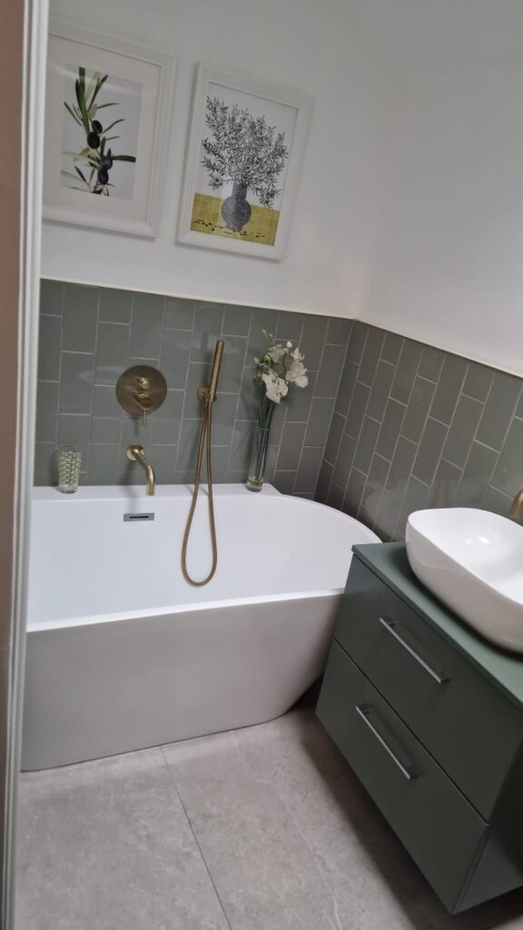 A modern bathroom featuring a freestanding bathtub, a sink, and green tiles on the wall. - London