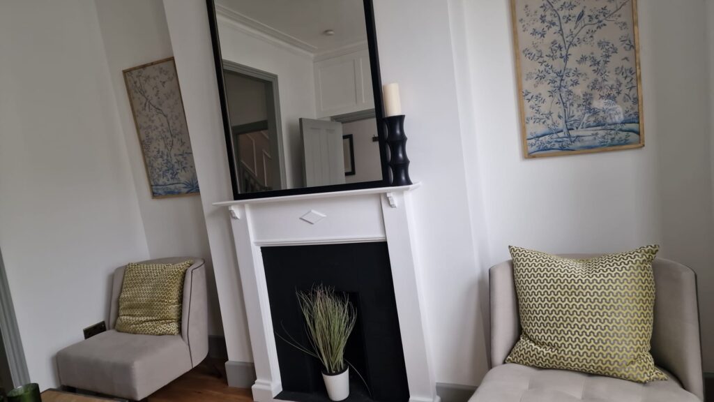 Living Room & Bedroom Renovation | London & Home Counties 16 Living room featuring a large decorative mirror above a fireplace and two armchairs with patterned cushions. - London