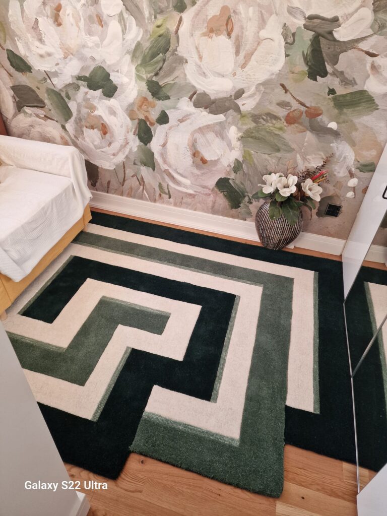 Living Room & Bedroom Renovation | London & Home Counties 23 Geometric patterned area rug in green and cream colours with a floral wall behind it. - London