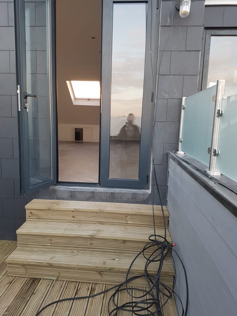 Garden Buildings & Outdoor Spaces | London & Home Counties 3 Wooden steps leading up to a glass door with a reflection of a person in the glass. - London