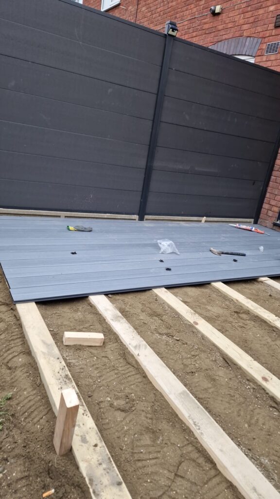 Garden Buildings & Outdoor Spaces | London & Home Counties 19 Grey composite decking boards laid on a wooden frame in a construction setting. - London