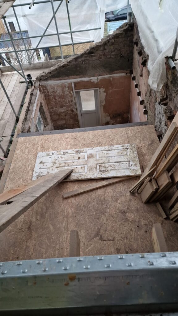View of an interior construction site showing wooden planks and an unfinished wall. - Watford