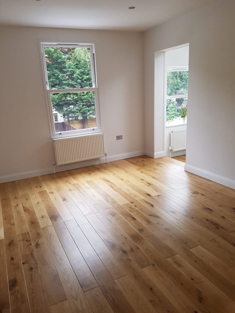 Living Room & Bedroom Renovation | London & Home Counties 26 An empty room featuring wooden flooring and large windows allowing natural light. - London